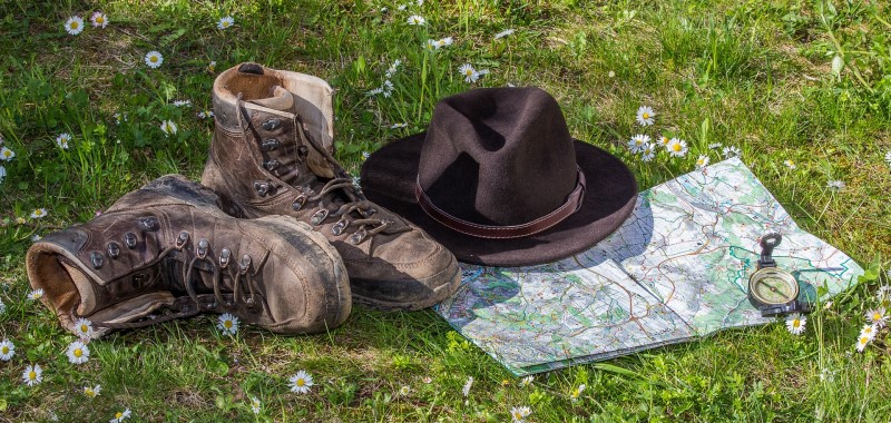 Wanderschuhe und Hut auf Wanderkarte mit Kompass